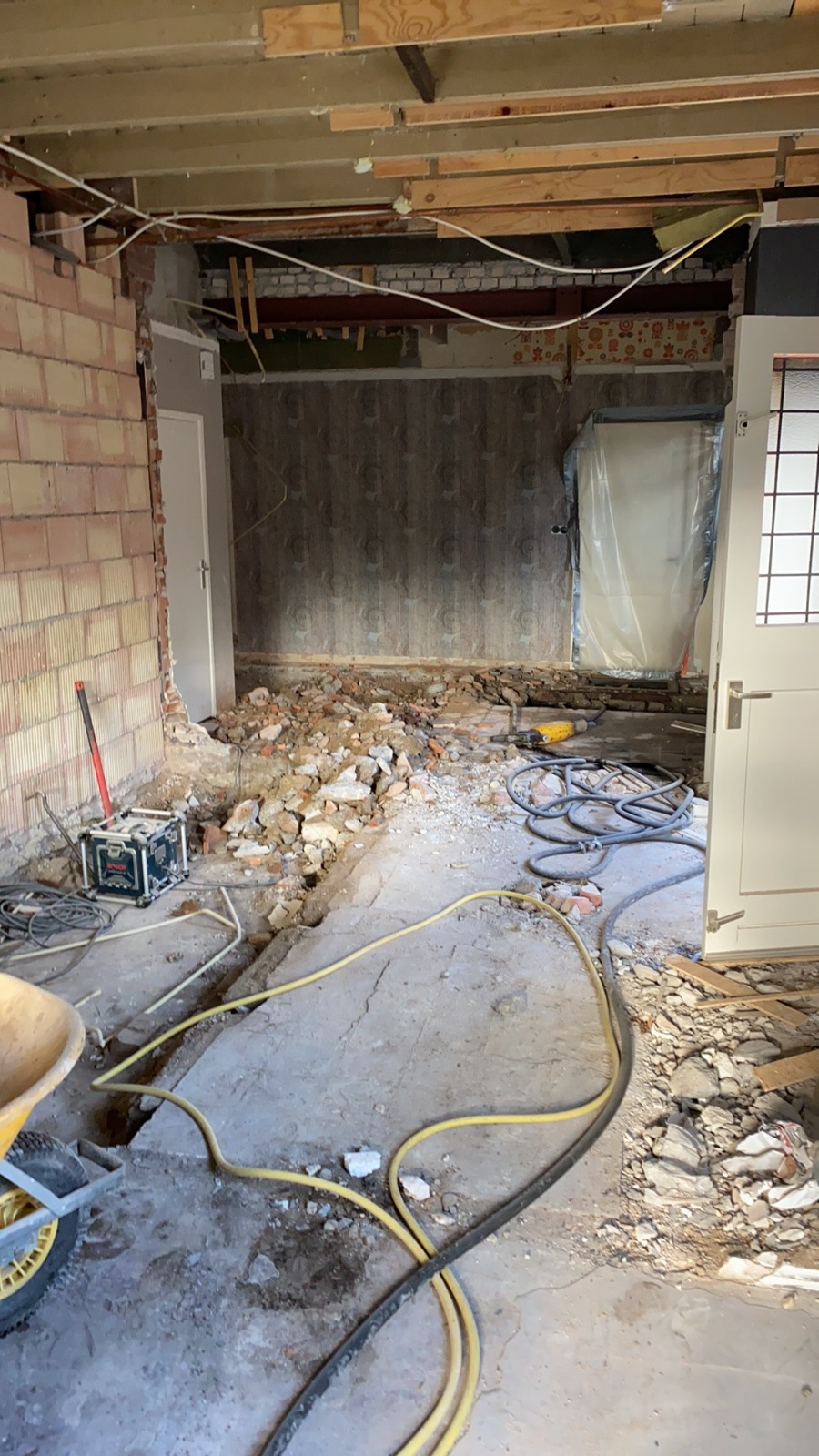 Woning tijdens binnensloop met geopende wanden, vrijgelegde balken en verwijderde vloer