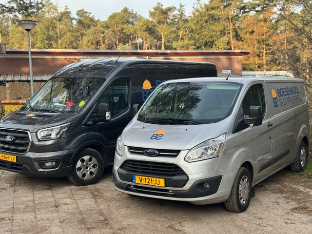Twee bestickerde werkbussen van Boesenkool Sloopwerken naast elkaar op locatie
