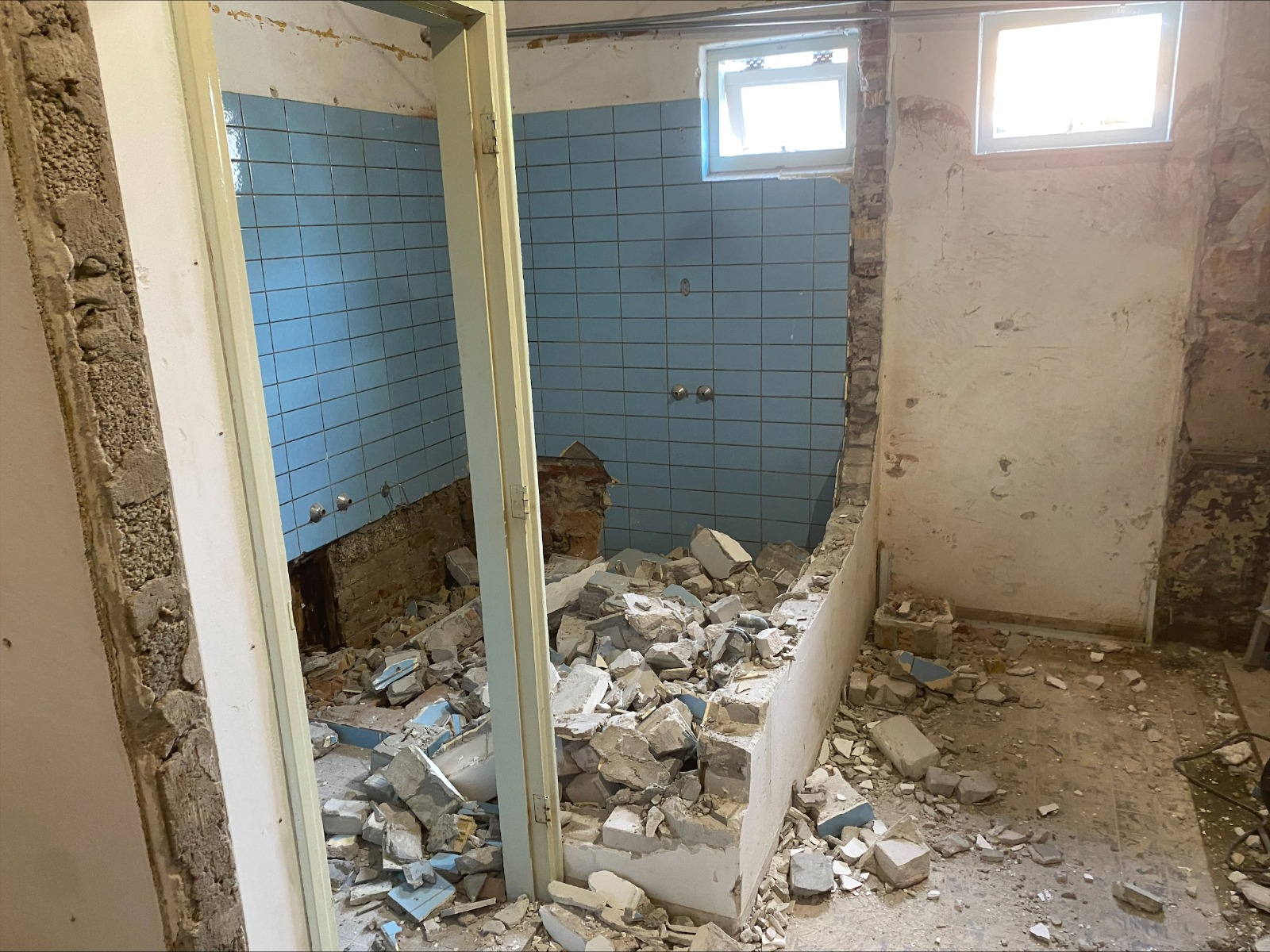 Badkamer tijdens selectieve sloop met verwijderd metselwerk, tegelwerk en gescheiden puin