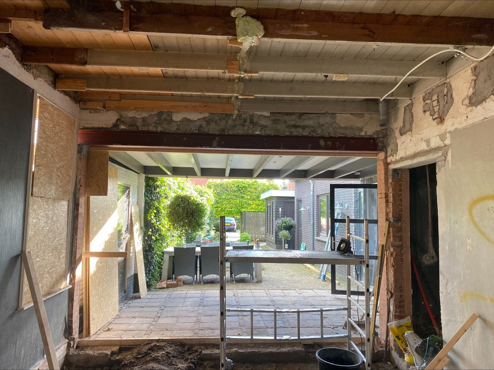 Brede doorgang in een woonkamer met zichtbare stalen ligger na selectieve sloop
